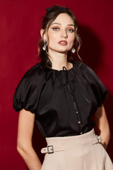 High-waisted A-line silk skirt with structured buckled waistband and tailored front overlap